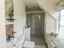 A bathroom with a shower, sink, and toilet at 13 School Road in Newton Abbot