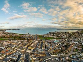 An aerial view of a coastal town with buildings and sea at 13 School Road, Kingskerswell