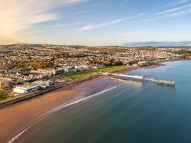 An aerial view of a beach with a pier and buildings at 13 School Road Kingskerswell