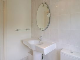 A bathroom with a sink, toilet, and mirror at Hawksdown Lyme Regis