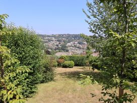 A garden with grass and bushes overlooking a city at Hawksdown in Lyme Regis