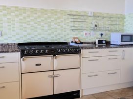 A kitchen with stove, microwave and countertop at Hawksdown in Lyme Regis