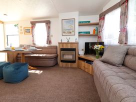 A living room with a sofa, coffee table, and television at 21 Poplar Avenue in Felixstowe, Suffolk