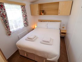 A bedroom with a double bed and shelves at 21 Poplar Avenue, Felixstowe, Suffolk