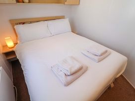 A bedroom with a bed and towels at 21 Poplar Avenue in Felixstowe, Suffolk