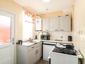 A kitchen with sink, cabinets, microwave, kettle and stove at Dover Retreat in 