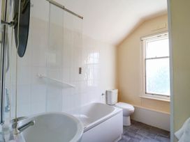 A bathroom with a shower, bathtub, toilet and window at Dover Retreat