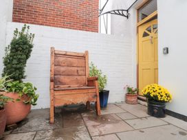 An outdoor area with a wooden chair and potted plants at Bohemian Beach Cottage in Bournemouth