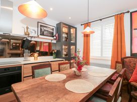 A dining room with a wooden table and chairs at Bohemian Beach Cottage in Bournemouth