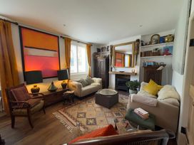 A living room with a sofa, armchair and fireplace at Bohemian Beach Cottage in Bournemouth
