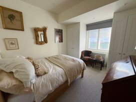 A bedroom with a bed and chair at Bohemian Beach Cottage in Bournemouth