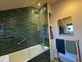 A bathroom with a shower and bathtub at Bohemian Beach Cottage Bournemouth