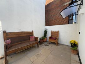 An outdoor seating area with benches and potted plants at Bohemian Beach Cottage in Bournemouth