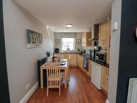A kitchen with cooking appliances and a dining table at Stanton House - Abbey View, Flat 3