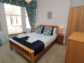 A bedroom with a bed, bedside table, and wardrobe at Stanton House - Abbey View, Flat 3