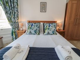 A bedroom with a bed and decorative pillows at Stanton House - Abbey View, Flat 3