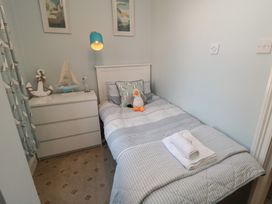 A bedroom with a single bed and a dresser at Stanton House - Abbey View, Flat 3