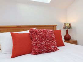 A bedroom with pillows and a lamp at Butterfly Days in Bideford