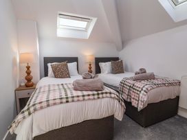 A bedroom with two beds and a lamp at Butterfly Days in Bideford