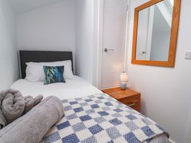A bedroom with a single bed and a lamp at Butterfly Days in Bideford