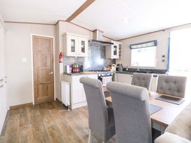 A kitchen with cabinets and dining area at 17 Castle Walk Great Yarmouth