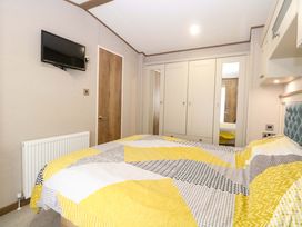 A bedroom with a bed, wardrobe, and television at 17 Castle Walk in Great Yarmouth