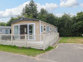 A caravan with a deck and trees at 17 Castle Walk Great Yarmouth