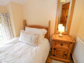 A bedroom with a bed and nightstand at Brondderwen in Blaenau Ffestiniog