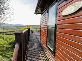 An outdoor area with a wooden deck and a view of the landscape at Summertime Lodge Rhyd-y-Foel near Abergele