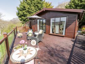 A deck with chairs and a table at Summertime Lodge Rhyd-y-Foel near Abergele