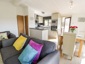 A kitchen with a sofa and table at Summertime Lodge in Rhyd-y-Foel near Abergele