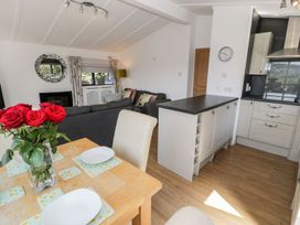 A kitchen with a dining area and a sofa at Summertime Lodge in Rhyd-y-Foel near Abergele