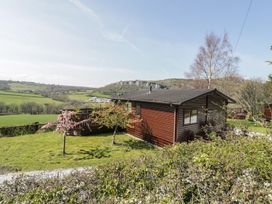 A cabin with a deck in an outdoor area at Alpine Lodge in Rhyd-y-Foel near Abergele