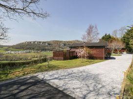 An outdoor area with a lodge and landscaping at Alpine Lodge in Rhyd-y-Foel near Abergele
