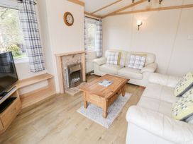 A living room with a sofa and coffee table at Alpine Lodge Rhyd-y-Foel near Abergele