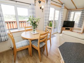 A dining room with a table and chairs at Alpine Lodge in Rhyd-y-Foel near Abergele