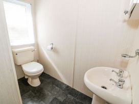 A bathroom with a toilet and sink at Alpine Lodge Rhyd-y-Foel near Abergele