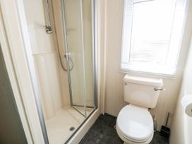 A bathroom with a shower and toilet at Alpine Lodge in Rhyd-y-Foel near Abergele