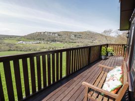 An outdoor area with a bench and a view of the mountains at Alpine Lodge in Rhyd-y-Foel near Abergele