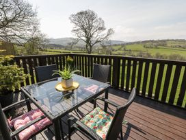 Outdoor seating area with a table and chairs at Alpine Lodge Rhyd-y-Foel near Abergele