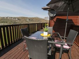 An outdoor dining area with seats and table at Alpine Lodge Rhyd-y-Foel near Abergele