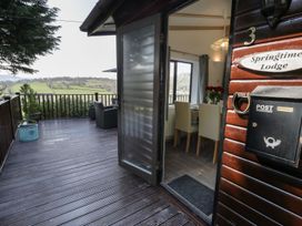 An outdoor deck with seating and a table at Springtime Lodge Rhyd-y-Foel near Abergele