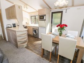 A kitchen with a dining area at Springtime Lodge Rhyd-y-Foel near Abergele