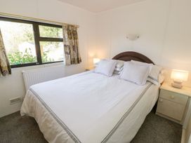 A bedroom with a bed and windows at Springtime Lodge in Rhyd-y-Foel near Abergele