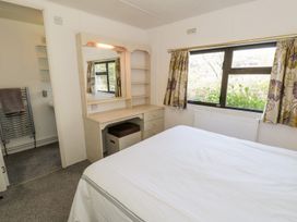 A bedroom with a bed and a desk with a mirror at Springtime Lodge Rhyd-y-Foel near Abergele