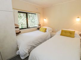 A bedroom with two beds and a window at Springtime Lodge in Rhyd-y-Foel near Abergele