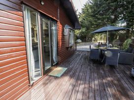 An outdoor terrace with a sliding door and furniture at Springtime Lodge in Rhyd-y-Foel near Abergele