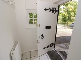 An entrance hall with a white door and radiator at Raglan Lodge Monmouth