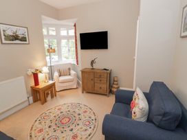 A living room with a sofa, coffee table, and television at Raglan Lodge in Monmouth