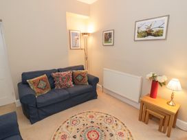 A living room with a sofa and table at Raglan Lodge in Monmouth